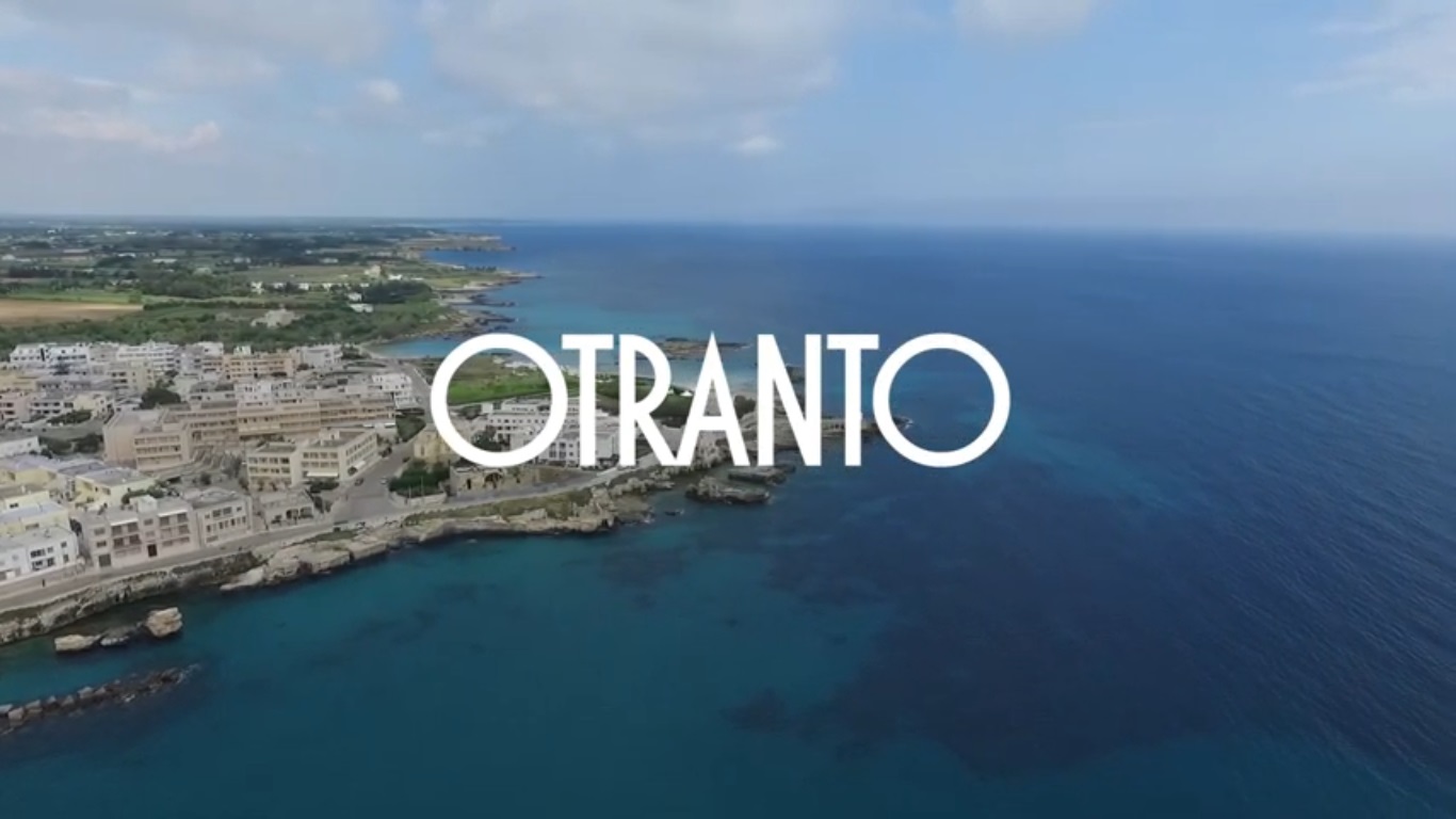 una veduta aerea da drone della costa di Otranto, con la scritta Otranto sovraimpressa